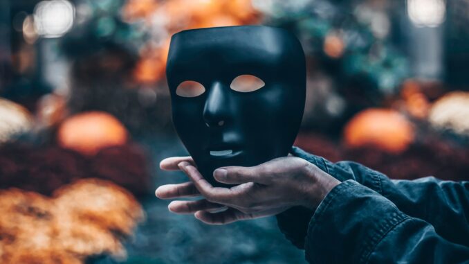 Person holding a mask following an AI sector study highlighting that record growth is masking serious challenges including skills, safety, infrastructure, security, and more, according to the authors of the report.