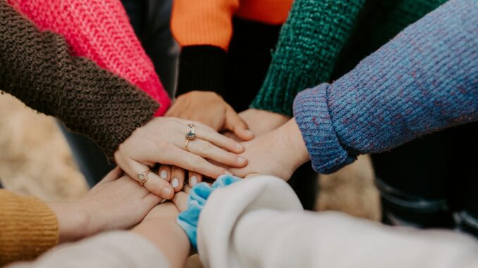 Alibaba Cloud overhauls AI partner initiative Team putting their hands in, illustrating Alibaba Cloud overhauling its global AI partner ecosystem.